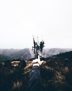 person pointing mountain during daytime thumbnail