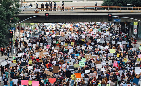 group of people performing rally on street under the bridge during daytime thumbnail