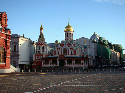 person walking white and red building at daytime thumbnail