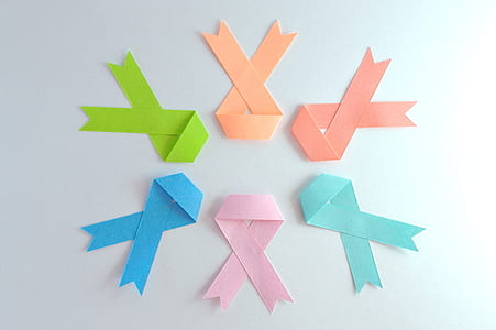 six assorted-color breast cancer ribbons on white surface thumbnail