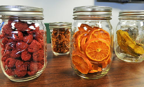 four clear glass mason jars filled with fruits thumbnail