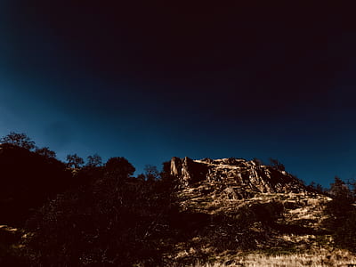 brown mountain under blue and black sky thumbnail