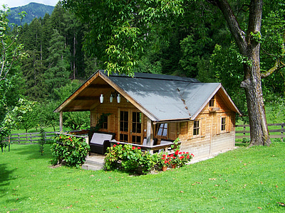 brown and gray wooden house near tree during daytime thumbnail