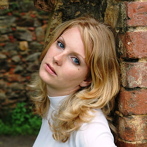 photo of woman leaning on brick wall thumbnail