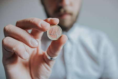 Person Holding Round Gold-colored Coin thumbnail