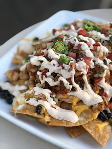 nachos topped with ground beef and vegetables thumbnail