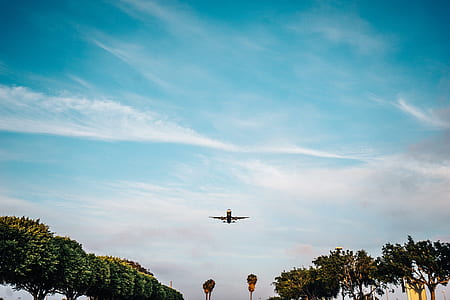 low-angle photography of airplane flying under blue sky thumbnail