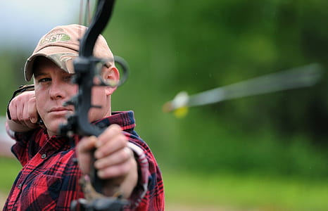 photography of man holding comound bow thumbnail