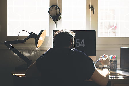 man wearing black shirt in front of black adjustable lamp thumbnail