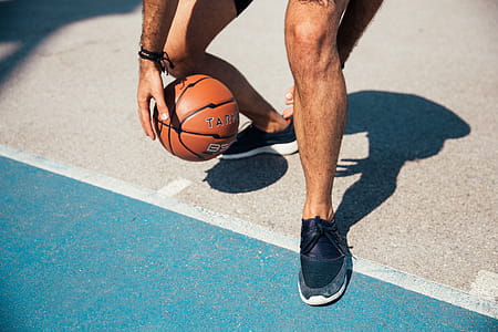 A young player dribbling the basketball in the sunlight thumbnail