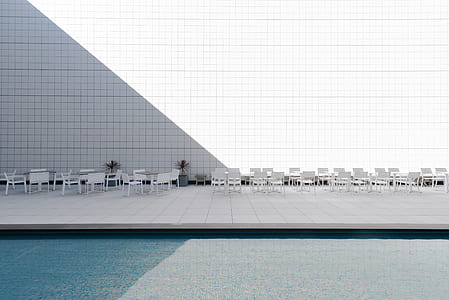 white steel patio tables and chairs near body of water thumbnail