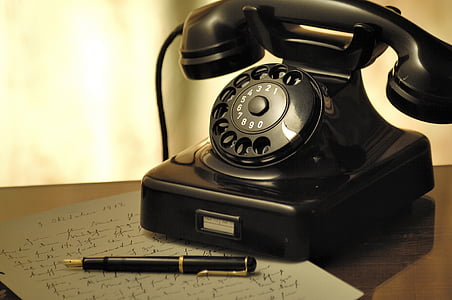 black rotary phone beside black pen thumbnail