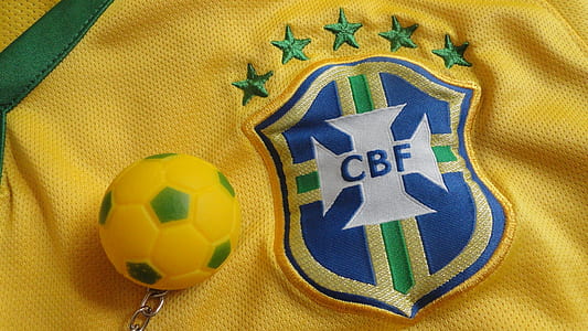close-up photography of soccer ball keychain on yellow CBF jersey shirt thumbnail