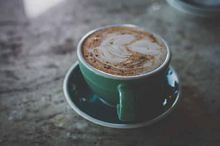 green ceramic coffee mug with saucer filled with brown substance thumbnail