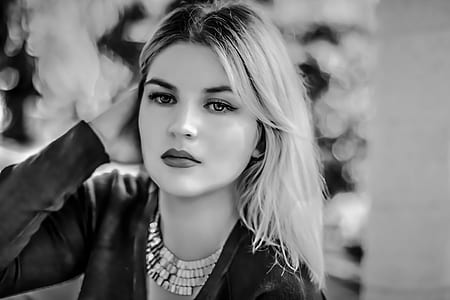 woman wearing long-sleeved shirt holding ear pose thumbnail