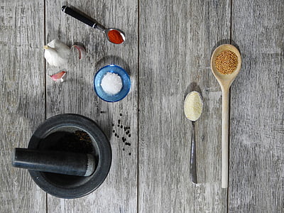 round black mortar and pestle near brown wooden ladle with powder thumbnail