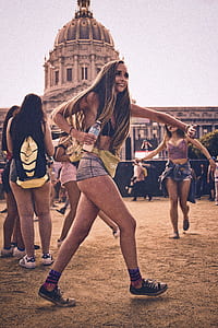 woman wearing blue denim shorts and black brassiere walking on brown sands thumbnail