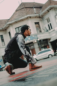 selective focus photo of man tying his Timberland boots thumbnail