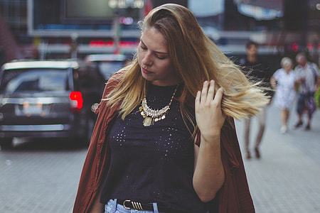 blonde fixing her hair while walking at the street thumbnail