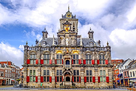 gray and red gothic building under white clouds thumbnail