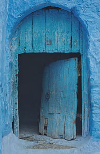 blue wooden door opened on blue concrete wall thumbnail