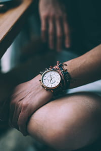 selective focus photography of person wearing round white and gold-colored chronograph watch at 2:34 thumbnail
