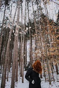 woman standing near bare trees thumbnail