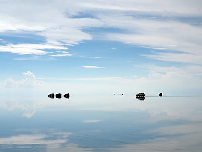body of water under clouds at daytime thumbnail