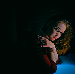 woman holding her shoulder inside dark room thumbnail