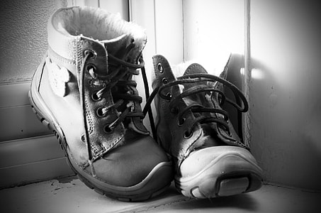 grayscale photography of black leather work boots thumbnail