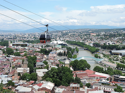 cable car above buildings in distant of mountain thumbnail
