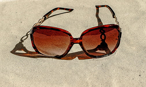 tortoiseshell sunglasses on white sand at daytime thumbnail