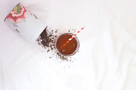 filled clear drinking glass with straw on white surface thumbnail