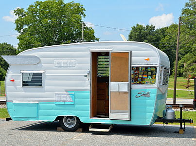teal and white travel trailer in concrete road thumbnail