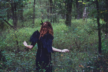 woman standing on green leafed plants during daytime thumbnail