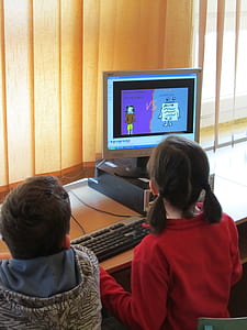 boy and girl using desktop computer in the room thumbnail