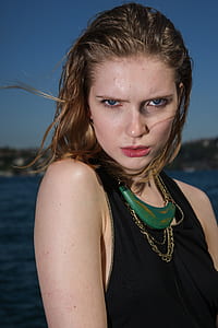 woman in black tank top near body of water thumbnail