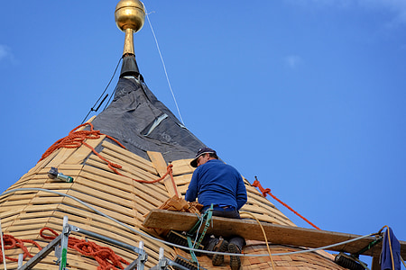 photo of man sitting on plank repairing on roof thumbnail