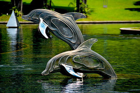 two statues of dolphins in water thumbnail