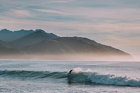 person surfing on waves during daytime thumbnail