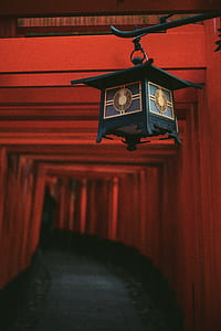 shallow focus photograph of black lantern in front of orange tunnel thumbnail