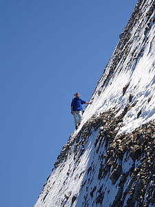 person climbing steep snow covered mountain thumbnail