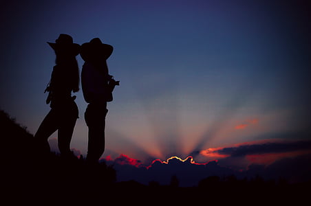 silhouette of two cowgirls standing on a cliff thumbnail