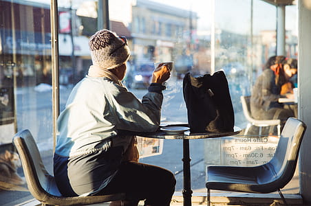 person sitting on chair inside a room while holding a cup thumbnail
