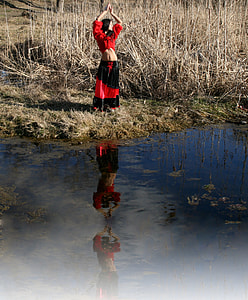 woman wearing red and black dress standing near lake thumbnail