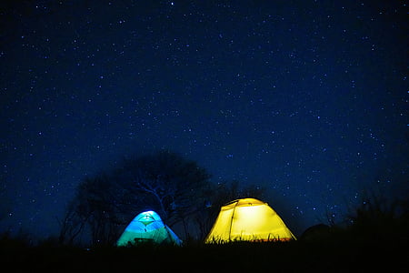 landscape photography of blue and yellow tents during nighttime thumbnail