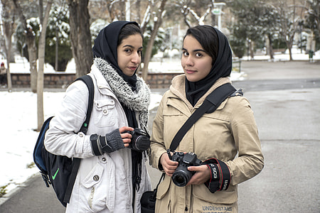 two woman's standing while holding cameras during snow time thumbnail