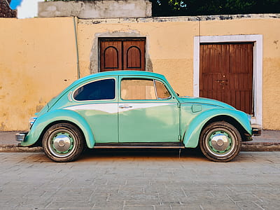 photo of parked classic teal Volkswagen beetle car near the door thumbnail