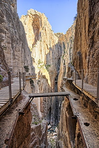 brown wooden bridge on rocky mountains thumbnail