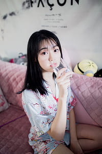 woman drinking water from a glass while sitting on acouch thumbnail